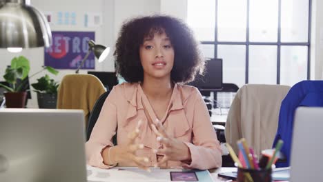 Portrait-of-african-american-female-designer-in-video-call-at-computer-in-casual-office,-slow-motion