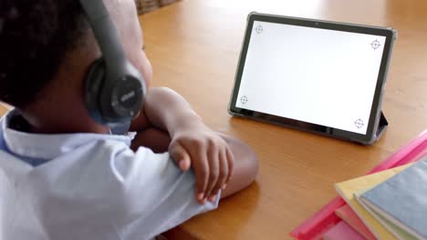 Niño-Afroamericano-Con-Auriculares-Usando-Tableta-En-Clase-En-Línea-En-Casa,-Cámara-Lenta,-Espacio-De-Copia
