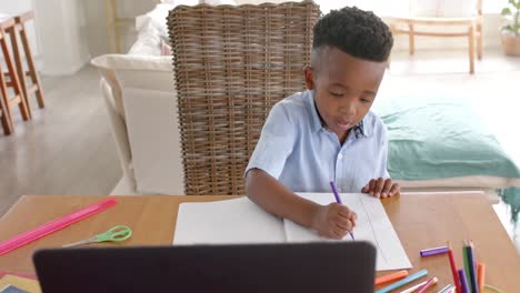 Feliz-Niño-Afroamericano-Usando-Una-Computadora-Portátil-Para-Clases-En-Línea-En-Casa,-Cámara-Lenta