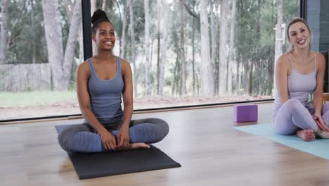 Happy-diverse-women-sitting-on-mats-in-yoga-class,-slow-motion