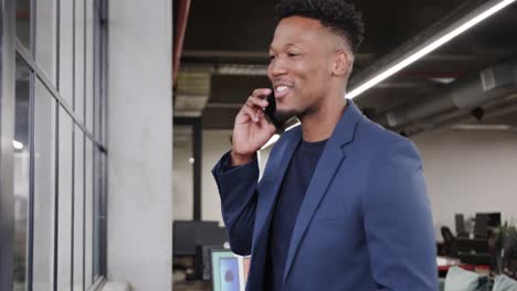 Happy-african-american-male-creative-talking-on-smartphone-at-casual-office,-in-slow-motion