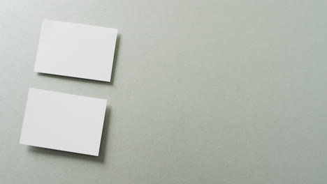Nahaufnahme-Von-Zwei-Stapeln-Weißer-Visitenkarten-Auf-Grauem-Hintergrund,-Kopierraum,-Zeitlupe