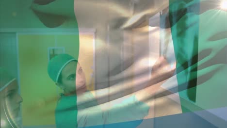 Animation-of-nigerian-flag-waving-over-diverse-female-surgeons-analyzing-patient-x-ray-reports