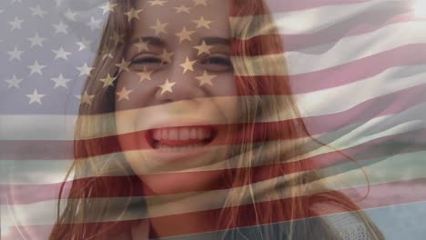 Animation-of-flag-of-america-waving-over-close-up-of-smiling-biracial-woman-standing-against-sea