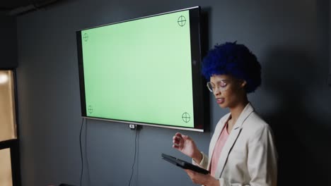 Biracial-casual-businesswoman-making-presentation-with-tablet-in-office,-copy-space,-slow-motion