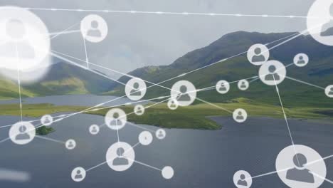 Animation-of-connected-icons-over-aerial-view-of-lake-and-mountain-against-cloudy-sky