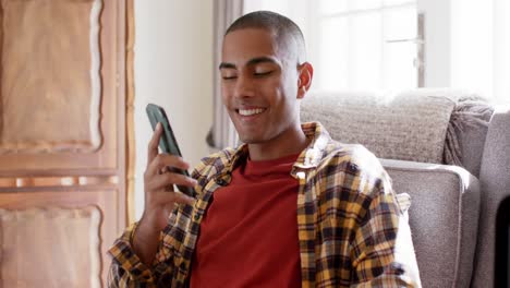 Hombre-Birracial-Feliz-Hablando-Por-Teléfono-Inteligente-En-Casa,-Cámara-Lenta