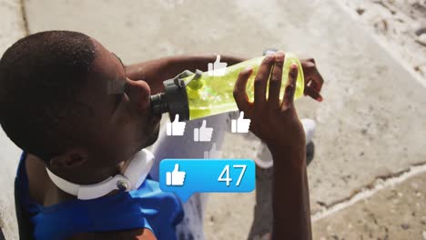 Animation-of-like-icons-with-numbers-over-african-american-male-athlete-with-bottle-using-phone