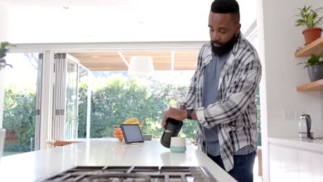 African-american-man-making-coffee-in-kitchen,-slow-motion