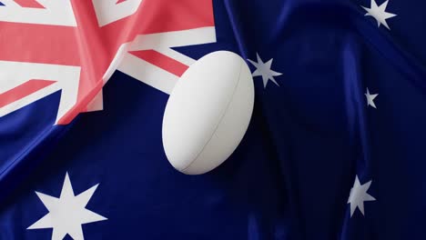 Pelota-De-Rugby-Blanca-Sobre-La-Bandera-De-Australia-Con-Espacio-Para-Copiar,-En-Cámara-Lenta
