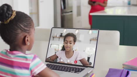 Chica-Afroamericana-Usando-Una-Computadora-Portátil-Para-Videollamada-Con-Un-Amigo-De-La-Escuela-Birracial-En-La-Pantalla