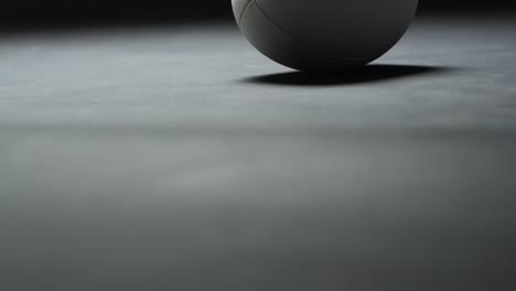White-rugby-ball-on-dark-background-with-copy-space,-slow-motion