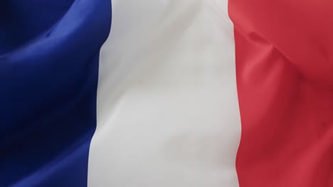 White-rugby-ball-rolling-over-waving-flag-of-france-with-copy-space,-in-slow-motion