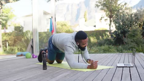 Fokussierter-Afroamerikanischer-Mann-Beim-Fitnesstraining-An-Deck-Im-Sonnigen-Garten,-Zeitlupe