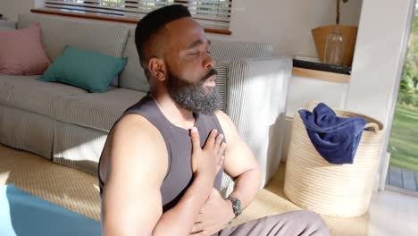 Fokussierter-Afroamerikanischer-Mann,-Der-Zu-Hause-Yoga-Auf-Einer-Matte-Praktiziert,-Zeitlupe