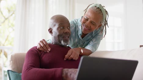 Glückliches-Afroamerikanisches-Seniorenpaar,-Das-Zu-Hause-Einen-Laptop-Benutzt,-Zeitlupe