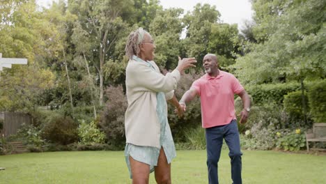 Glückliches-älteres-Afroamerikanisches-Paar,-Das-Händchen-Hält-Und-Im-Garten-Spaziert,-Zeitlupe