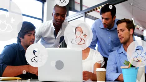 Animation-of-profile-icons-in-circles-over-diverse-coworkers-discussing-reports-on-laptop-at-office