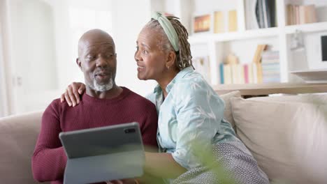 Glückliches-Afroamerikanisches-Seniorenpaar,-Das-Zu-Hause-Ein-Tablet-Benutzt,-Zeitlupe