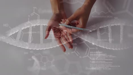 Animation-of-dna-strand-diagrams-with-data-processing-over-hands-of-biracial-woman-holding-pills