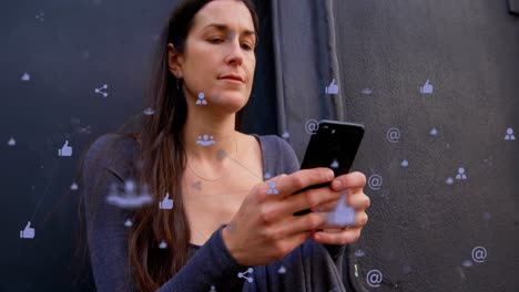 Animation-of-connected-icons-over-low-angle-view-of-happy-caucasian-woman-using-cellphone