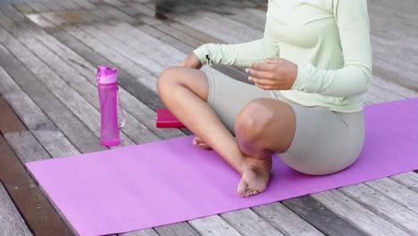 Mujer-Birracial-Enfocada-Practicando-Yoga-Y-Meditando-En-El-Jardín,-Cámara-Lenta