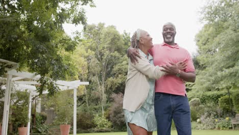 Glückliches-älteres-Afroamerikanisches-Paar,-Das-Sich-Umarmt-Und-Im-Garten-Spaziert,-Zeitlupe