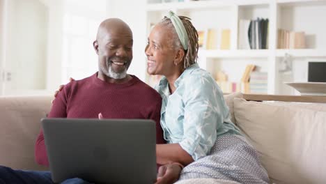 Feliz-Pareja-De-Ancianos-Afroamericanos-Usando-Una-Computadora-Portátil-En-Casa,-Cámara-Lenta