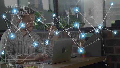Animation-of-network-of-connections-with-icons-over-caucasian-businessman-in-office