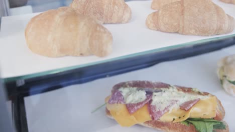 Close-up-of-fresh-and-tasty-sandwiches-and-croissants-over-glass-in-slow-motion