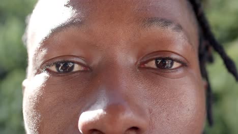Porträt-Glücklicher-Augen-Eines-Afroamerikanischen-Mannes-Im-Sonnigen-Garten,-Zeitlupe