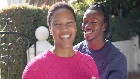 Porträt-Eines-Glücklichen-Afroamerikanischen-Paares,-Das-Sich-Im-Sonnigen-Garten-Umarmt,-Zeitlupe