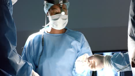 Diversos-Cirujanos-Con-Batas-Quirúrgicas-Operando-A-Un-Paciente-En-El-Quirófano,-En-Cámara-Lenta.