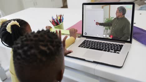 Composition-of-african-american-boy-and-girl-on-laptop-online-learning-with-biracial-male-teacher