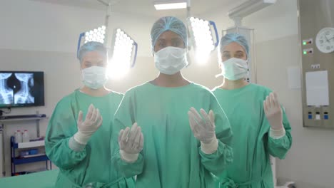Portrait-of-diverse-female-surgeons-wearing-surgical-gowns-in-operating-theatre,-slow-motion