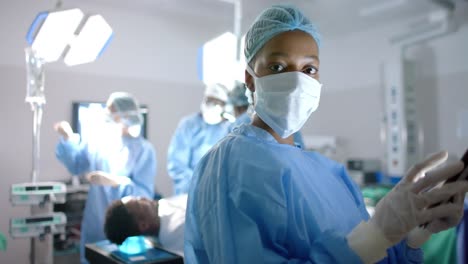 Portrait-of-african-american-female-surgeon-using-tablet-in-operating-theatre,-slow-motion