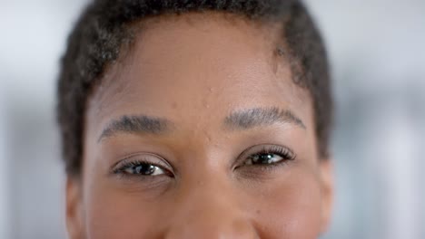 Close-up-of-portrait-of-african-american-female-doctor-looking-at-camera,-slow-motion