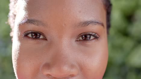 Retrato-De-Ojos-Felices-De-Una-Mujer-Afroamericana-En-Un-Jardín-Soleado,-Cámara-Lenta