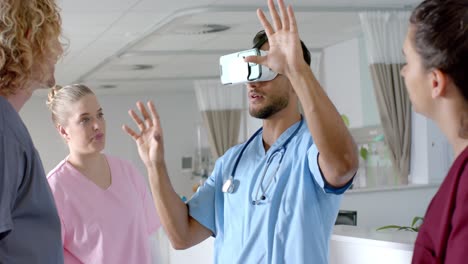Biracial-male-doctor-using-vr-headset-with-diverse-doctors-at-hospital,-slow-motion