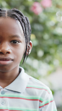 Vertical-video-of-half-portrait-of-happy-african-american-boy-in-nature,-slow-motion