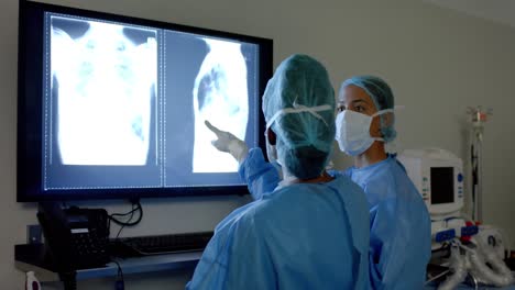 Verschiedene-Chirurgen-In-OP-Kitteln-Betrachten-Röntgenaufnahmen-Im-Operationssaal,-Zeitlupe