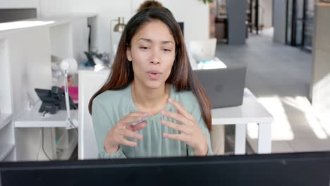 Biracial-casual-businesswoman-having-laptop-video-call-talking-in-office,-slow-motion