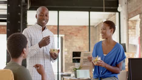 Felices-Colegas-Afroamericanos-Discutiendo-Trabajo-Y-Almorzando-En-Una-Oficina-Creativa,-En-Cámara-Lenta