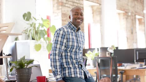 Portrait-of-happy-african-american-casual-businessman-in-creative-office-in-slow-motion