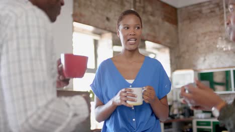 Fröhliche-Afroamerikanische-Kollegen-Reden-Und-Trinken-Kaffee-Im-Kreativbüro,-Zeitlupe