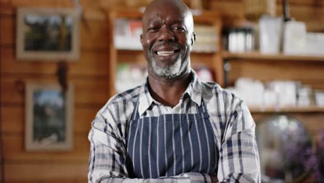 Portrait-of-happy-senior-african-american-male-shopkeeper-at-health-food-shop,-slow-motion