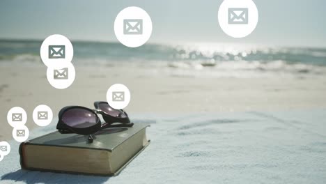 Animation-of-network-of-social-media-email-icons-over-book-and-sunglasses-on-beach