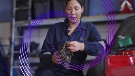 Animation-of-purple-pattern-moving-over-biracial-female-mechanic