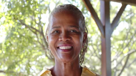 Porträt-Einer-Glücklichen-älteren-Afroamerikanischen-Frau-Auf-Der-Sonnigen-Terrasse,-Zeitlupe