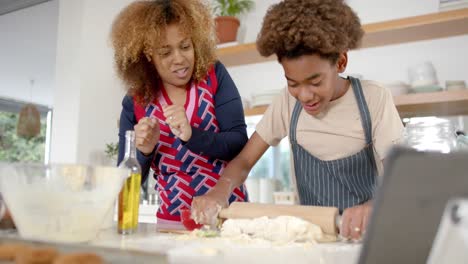 Glückliche-Afroamerikanische-Mutter-Und-Sohn-Backen-In-Der-Küche,-Zeitlupe